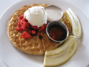 waffles with cashew cream, maple syrup, and fruit salad
